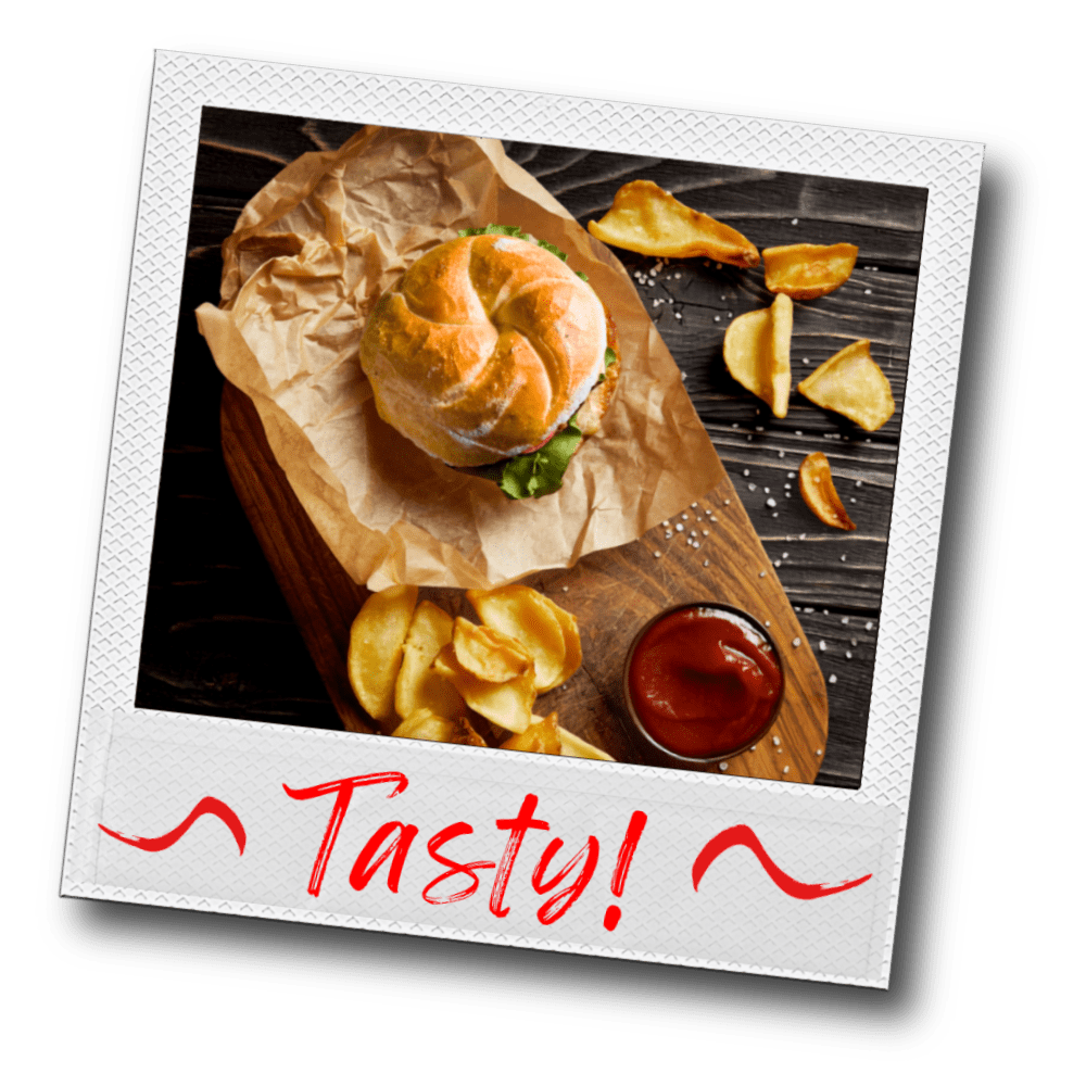 Polaroid photo of a Kaiser roll sandwich with potato chips on a wooden board, accompanied by ketchup and sprinkled salt captioned "Tasty!" in red lipstick script lettering.